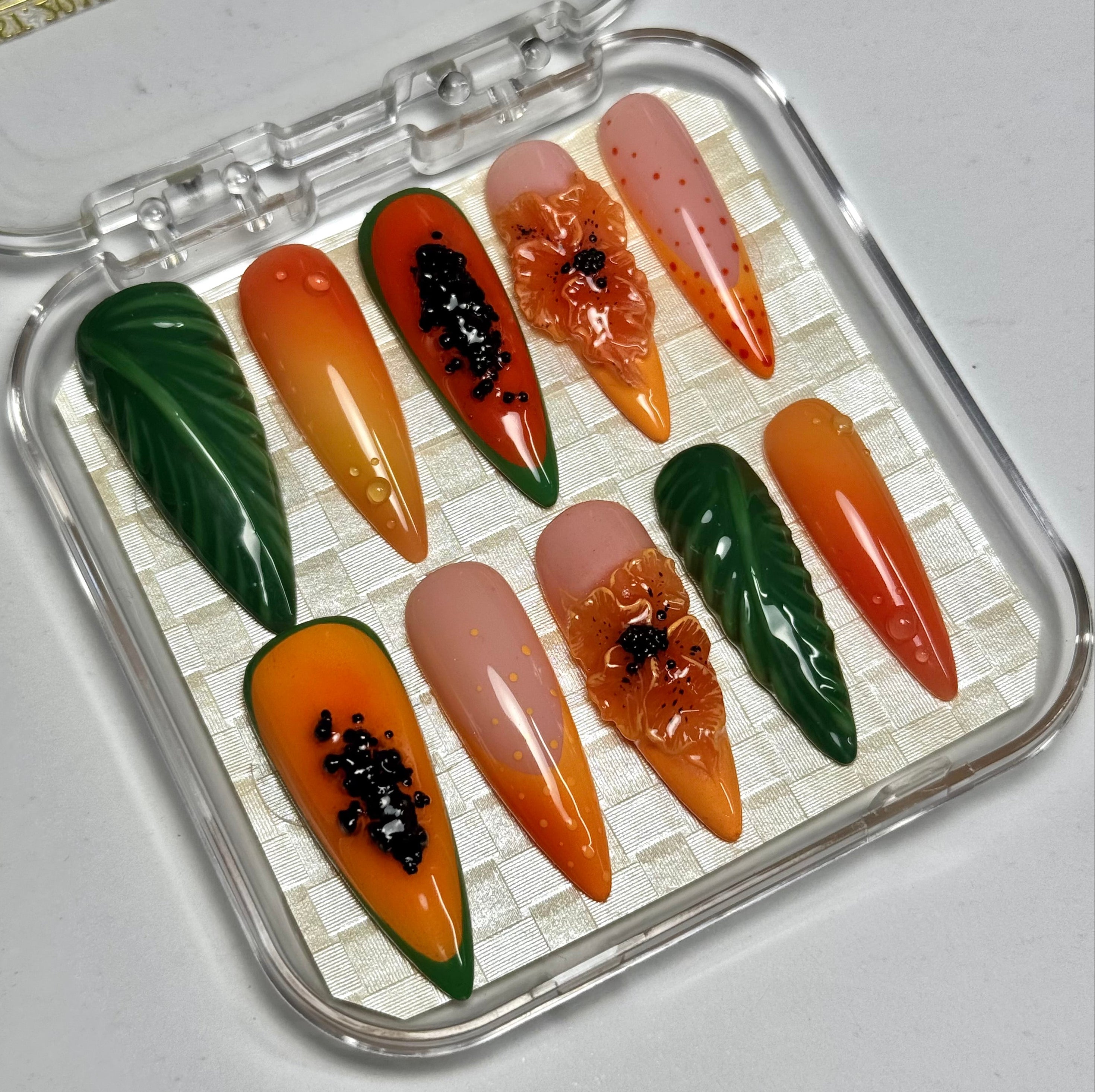 Set of artificial nails in a clear case with a brand name on a light gray background